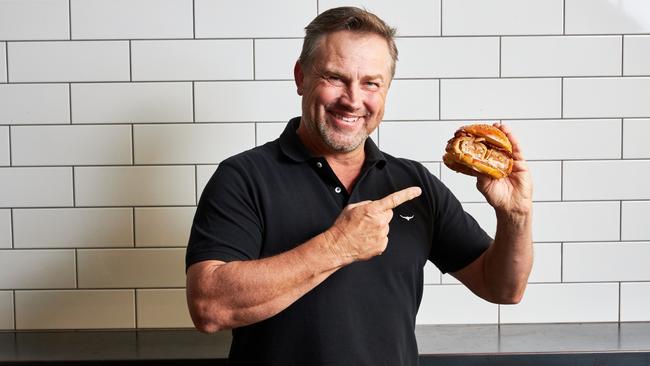 Adelaide Crows legend Tony Modra with Bread and Bone’s limited edition burger The Godra.