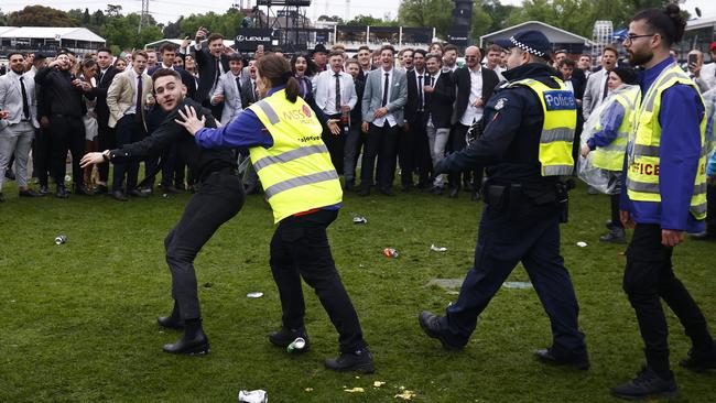 Police and security try to move on a racegoer for alleged anti-social behaviour at this year’s Derby Day. Photo: Getty