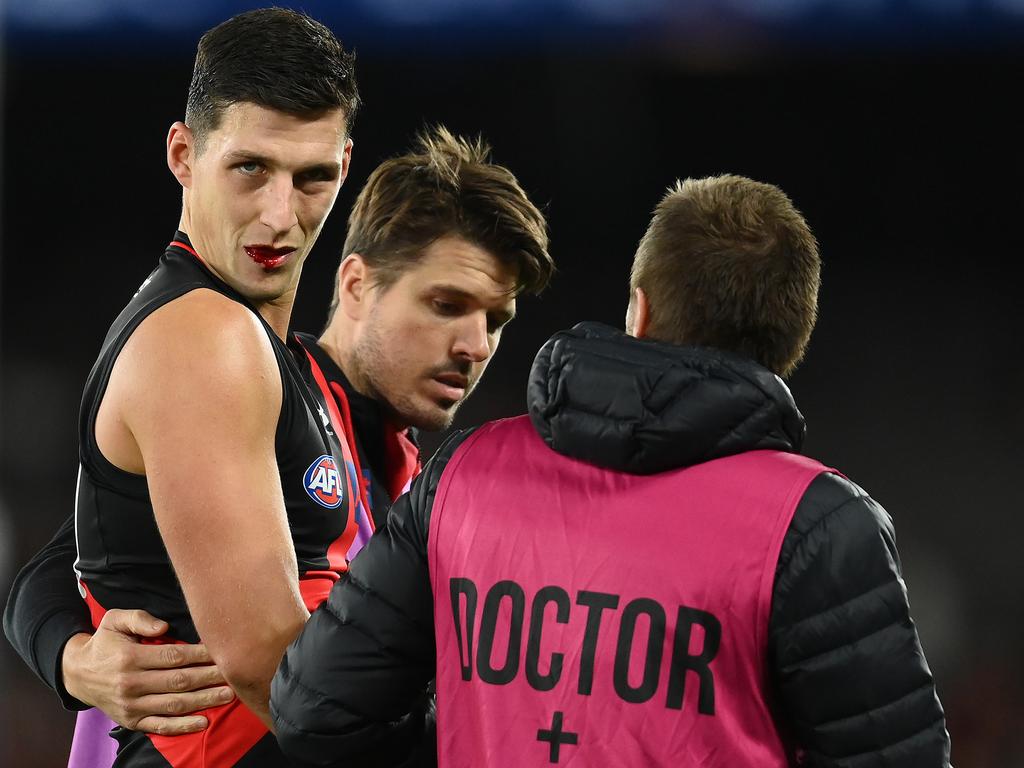 Sam Weideman is escorted from the field. Picture: Quinn Rooney/Getty