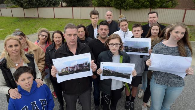 Darren St Ledger (middle) and neighbours hold designs of the planned development.