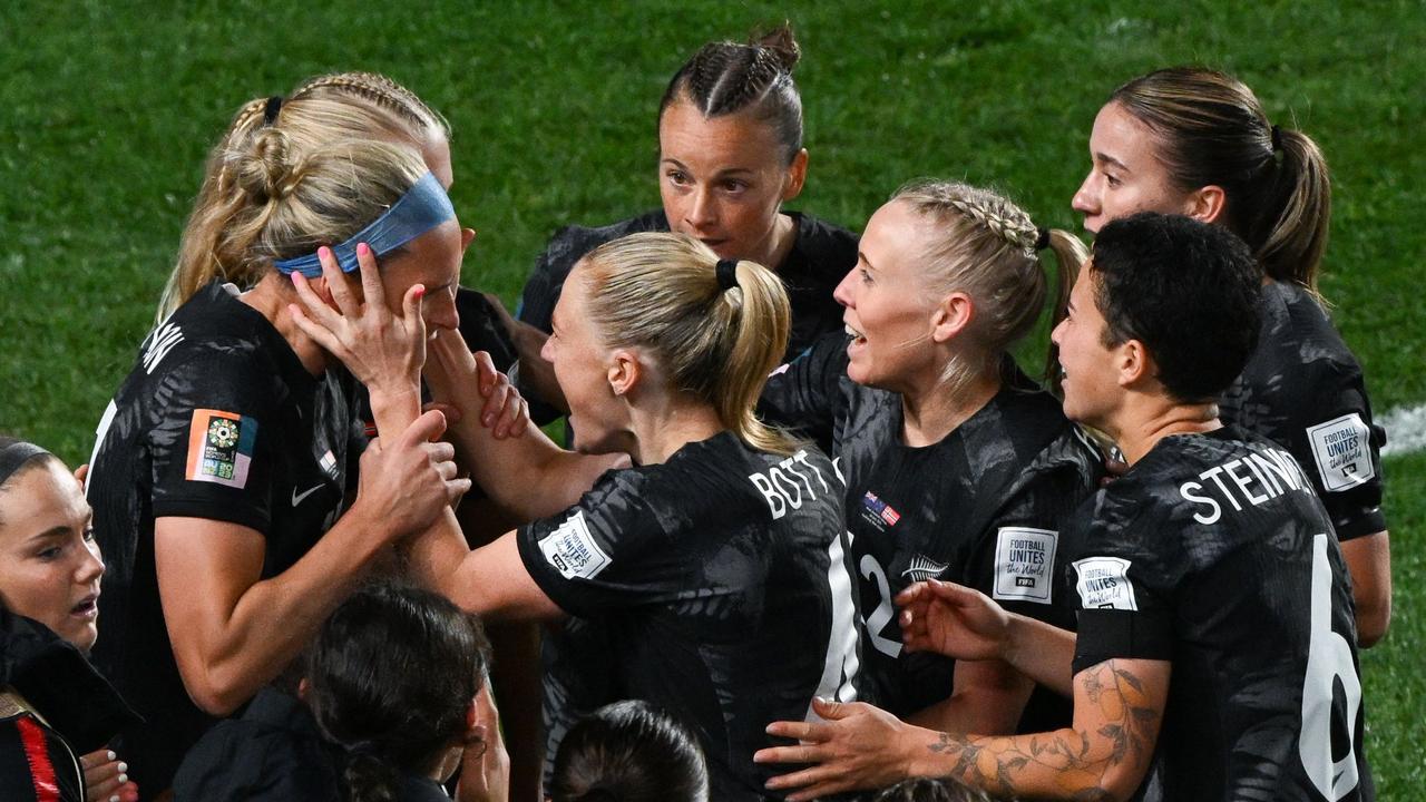 Hannah Wilkinson is mobbed by her New Zealand teammates after scoring against Norway. (Photo by Saeed KHAN / AFP)