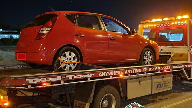 The red Hyundai hatchback is towed from the scene. Picture: SA Police