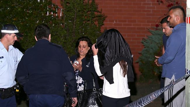 Police speak with the Winston Hills victim's mother and relatives at the scene last night. Picture: Bill Hearne