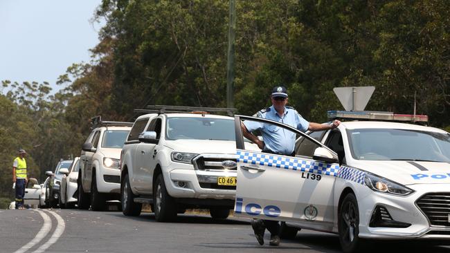 Hundreds of cars were lined up along Bendalong Road in Manyana on January 3 waiting to be escorted by police and RFS out of the fire ravaged area. The South Coast town was cut off for days and tourists and residents were without power. Picture: David Swift.