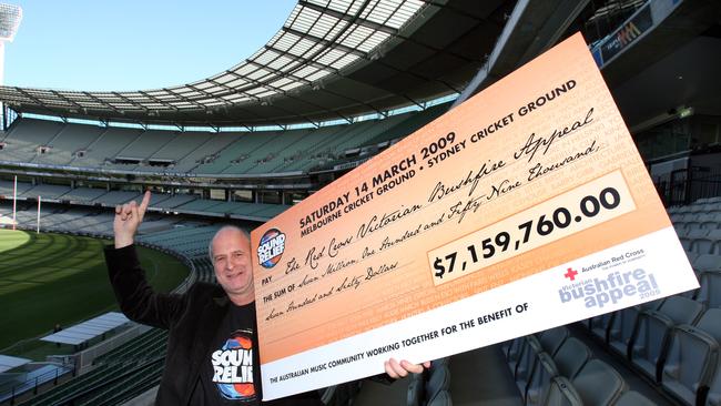 Michael Gudinski holds up a $7,159,760 cheque after the 2009 MCG and Sydney Sound Relief concerts.