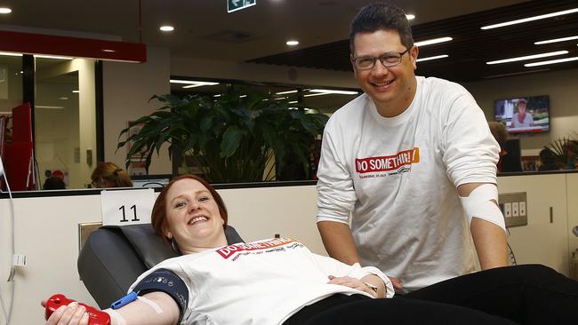 News Corp retail marketing executive Sarah Watson and <i>Southern Courier</i> editor Antony Field give blood at the Red Cross blood donor centre in Hunter St in Sydney CBD. Picture: John Appleyard