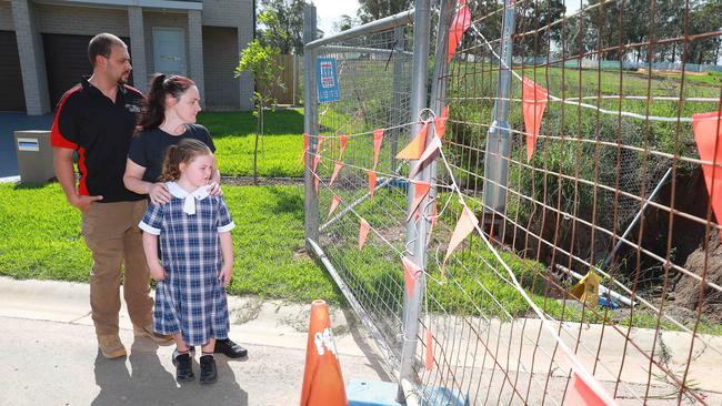 Raymond, Suzanne and their daughter Mia Phillips inspect the Sink hole on their street in Box Hill on Monday 24 February, 2020. Picture: AAP IMAGE / Angelo Velardo