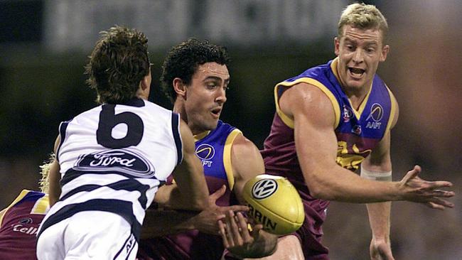 Nigel Lappin tries to dish off a handball to Michael Voss. Picture: David Kapernick