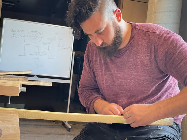 A workshop participant at work on his bow.