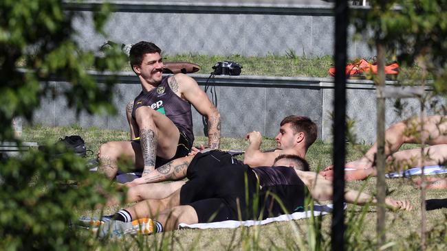 Players enjoy a stretch in the sunshine after training today. Picture: Michael Klein.