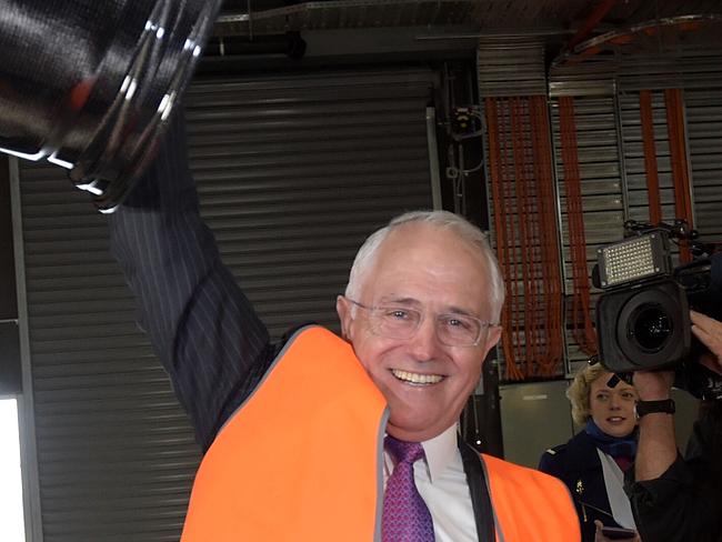 Australian Prime Minister Malcolm Turnbull lifts up a carbon fibre rim as he visits manufacturing business Carbon Revolution in the federal seat in Corangamite, in Geelong, Tuesday, May 24, 2016. (AAP Image/Lukas Coch) NO ARCHIVING