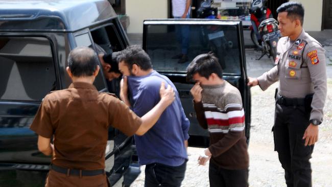 Indonesian police take away two men, convicted of having sex in contravention of sharia law, in Banda Aceh on May 10, 2017. Picture: AFP / Hendri Abik