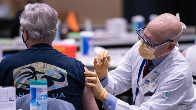 Chief clinical officer John Corman MD at Virginia Mason administers a dose of the Pfizer COVID-19 vaccine at the Amazon Meeting Center in downtown Seattle. Picture: AFP.