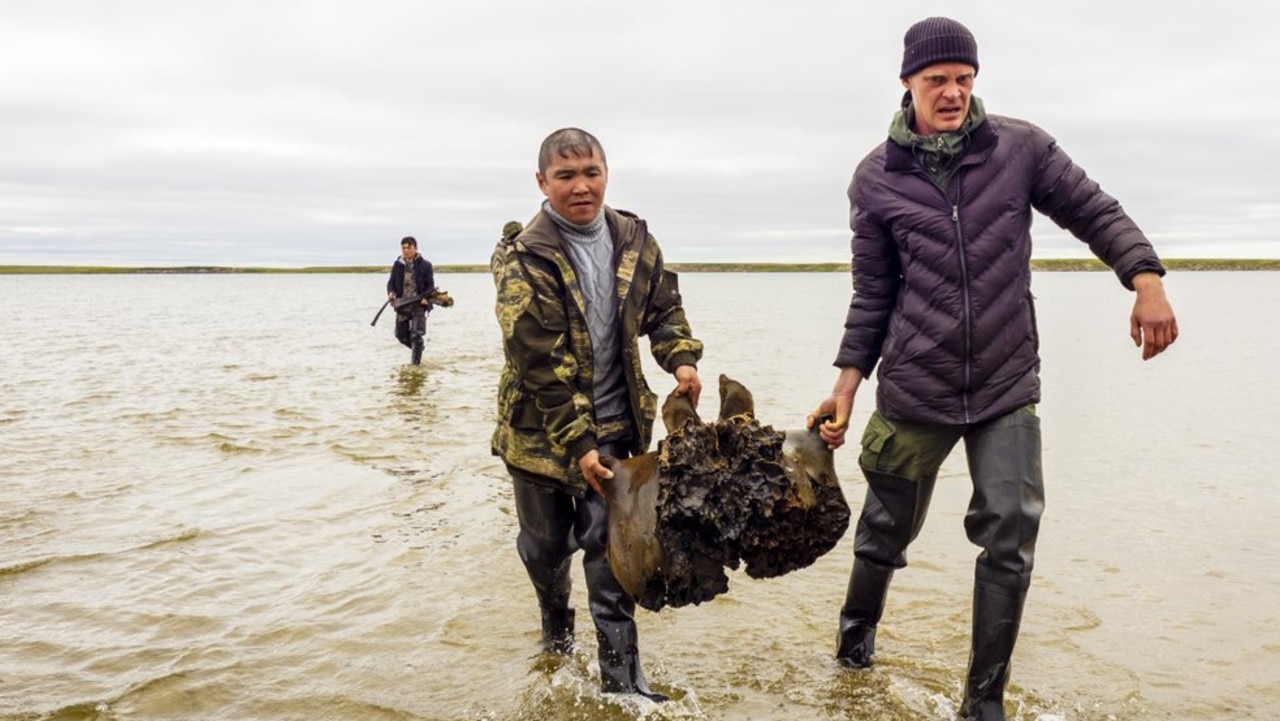 People carry a mammoth bone in the Pechevalavato Lake in the Yamalo-Nenets region, Russia, Wednesday, July 22, 2020. Picture: Russia Press Office via AP