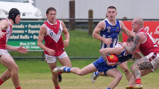 Red Hill’s Michael Griechen tackles a Langwarrin opponent as Harvey Stuart (left) and Harry Sullivan look on. Picture: Paul Churcher