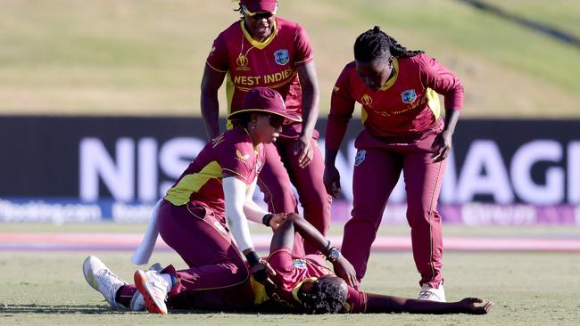 West Indies Shamilia Connell receives attention from teammates after collapsing on the field during the match against Bangladesh. (Photo by MICHAEL BRADLEY / AFP)