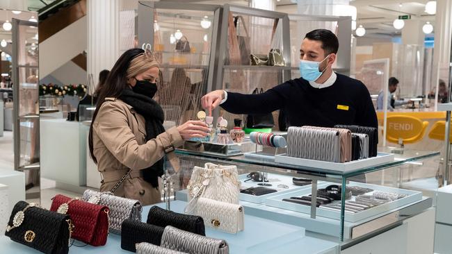 A retail worker serves a customer in a department store. Picture: AFP