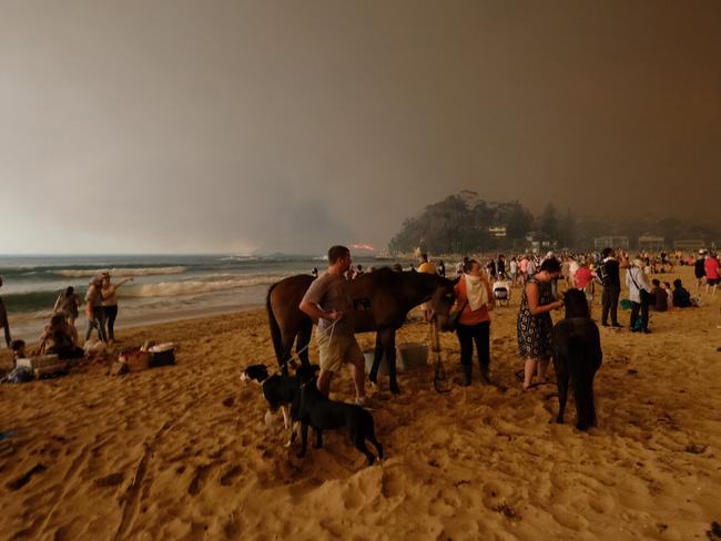Bushfire arrives into the township of Malua Bay NSW, just south of Batemans Bay. Locals seek refuge on the Malua Bay main beach beach as the fire approaches. Picture: Alex Coppel