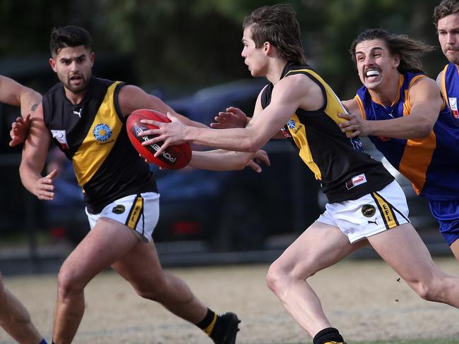 Jesse Cherry shrugs a tackle for Mitcham. Picture: Hamish Blair