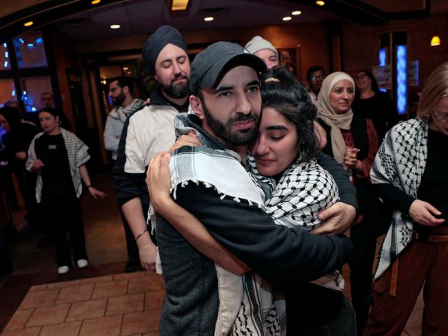 People hug at the Listen to Michigan watch party, a group who asked voters to vote uncommitted instead of for US President Joe Biden in Michigan's US Presidential primary election, during election night in Dearborn, Michigan on February 27, 2024. Activists in the key battleground -- where Biden's winning margin four years ago was 150,000 votes -- want Democrats to vote "uncommitted" to pressure the president to back off from his Israel support and call for an immediate ceasefire. Michigan's primary is expected to be another ticker-tape parade for former US President Donald Trump, but could deliver Democratic leader Joe Biden a bloody nose over the war in Gaza. (Photo by JEFF KOWALSKY / AFP)