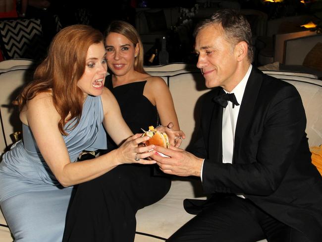 Been shredding, hun? Amy Adams lunges for co-star Christoph Waltz’s burger.