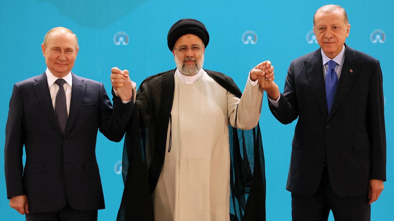 The three leaders pose for photos during Tuesday’s meeting in Tehran. Picture: Sergei Savostyanov/Sputnik/AFP