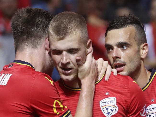 SOCCER - A-LEAGUE - Adelaide United v Melbourne Victory at Coopers Stadium. Sheer relief from Riley McGree as he gets his second goal - surrounded by team mates Ryan Strain and Nikola Mileusnic . Picture SARAH REED