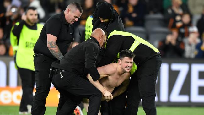 Cooper is restrained by security guards. Picture: AAP/Joel Carrett