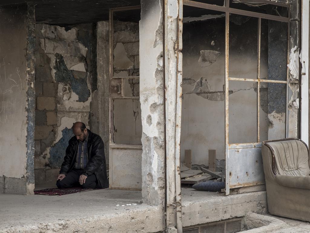 A man prays inside a destroyed building in Deir ez Zor. Picture: Ella Pellegrini