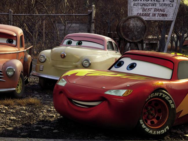 In a scene from Disney Pixar animated film Cars 3, Lightning McQueen (right, voiced by Owen Wilson) comes hood to hood with the roots of stock car racing.From left: River Scott (voice of Isiah Whitlock Jr.), Junior "Midnight" Moon (voice of Robert Glenn "Junior" Johnson), Smokey (voice of Chris Cooper), Louise "Barnstormer" Nash (voice of Margo Martindale)©2017 Disney Pixar. All Rights Reserved.