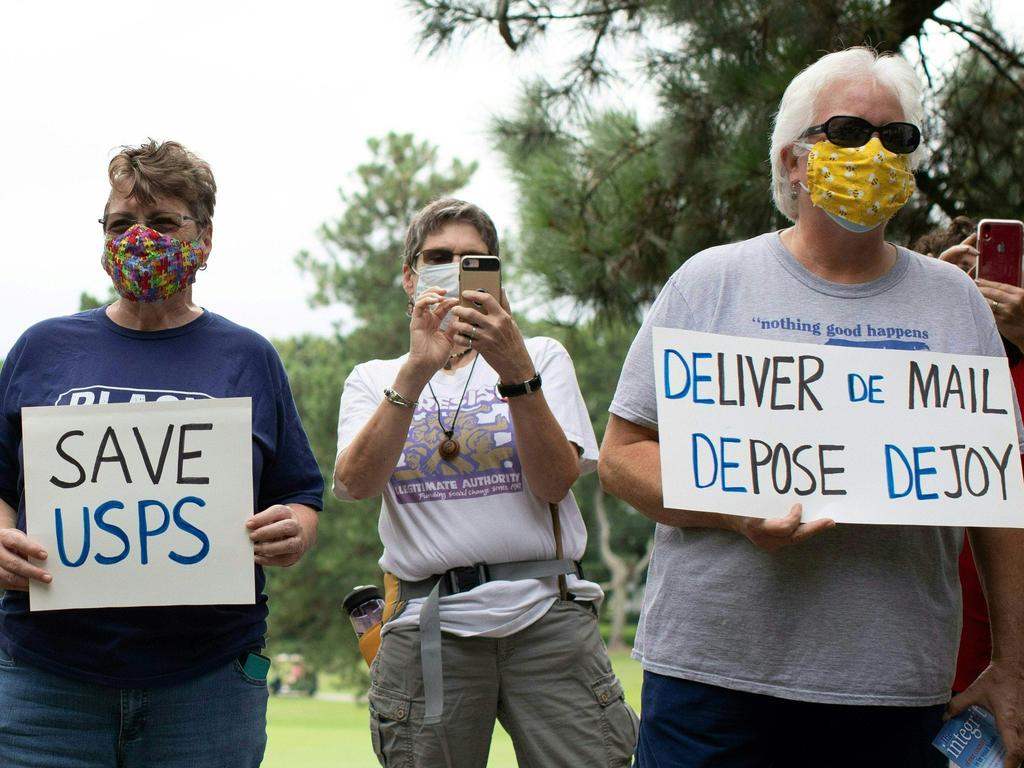 A group of protesters hold a demonstration in front of Postmaster General Louis DeJoy's home after he came under fire for what was perceived as steps ordered by the Trump administration to slow down the United States Postal Service to help suppress absentee votes. Picture: Logan Cyrus/AFP