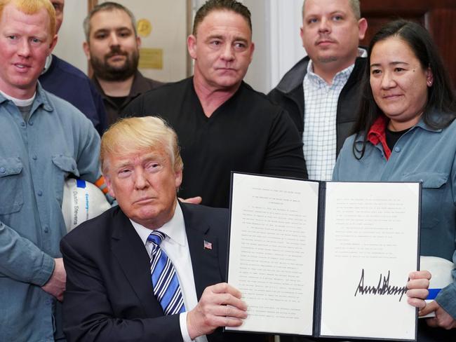 US President Donald Trump shows his signature on Section 232 Proclamations on Steel and Aluminum Imports. Picture: AFP