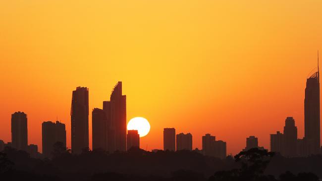 A golden start to Tuesday on the Gold Coast. The sun shines through smoke haze as it emerges over high-rises at Surfers Paradise. Picture: Glenn Hampson