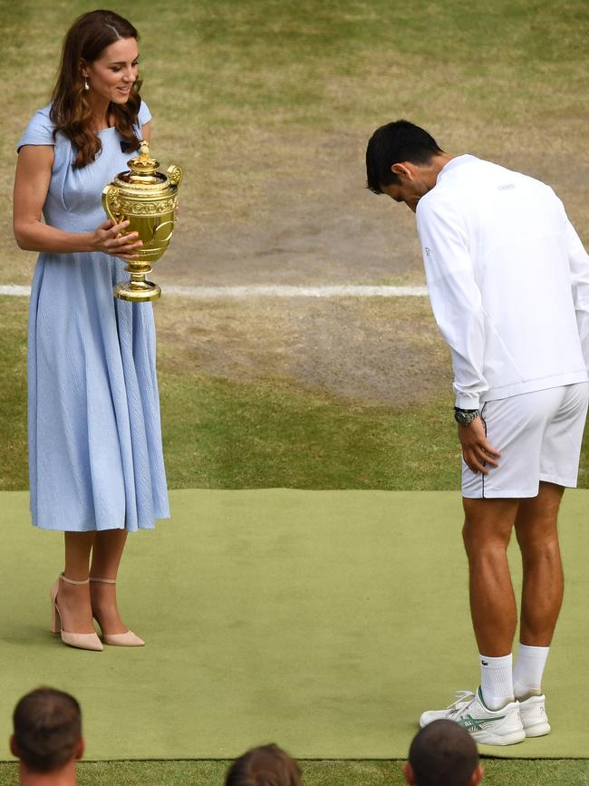 Novak Djokovic bows his head as Catherine, Duchess of Cambridge, presents him with the Wimbledon trophy. Picture: Getty Images