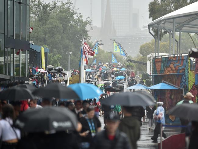 MELBOURNE, AUSTRALIA - JANUARY 20: Spectators take cover as rain falls on day one of the 2020 Australian Open at Melbourne Park on January 20, 2020 in Melbourne, Australia. (Photo by Morgan Hancock/Getty Images)