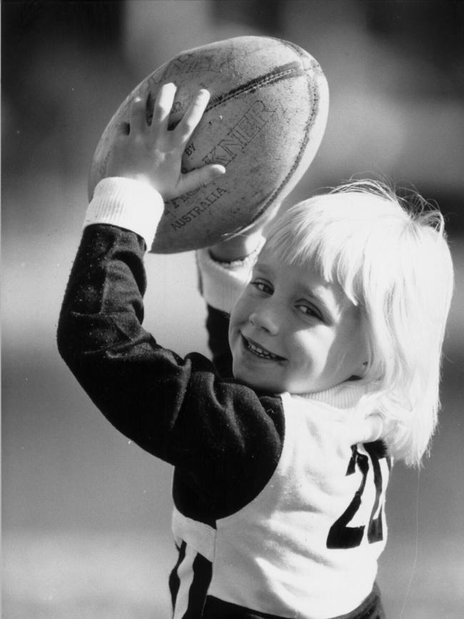 Erin Phillips holding a football aged 5.