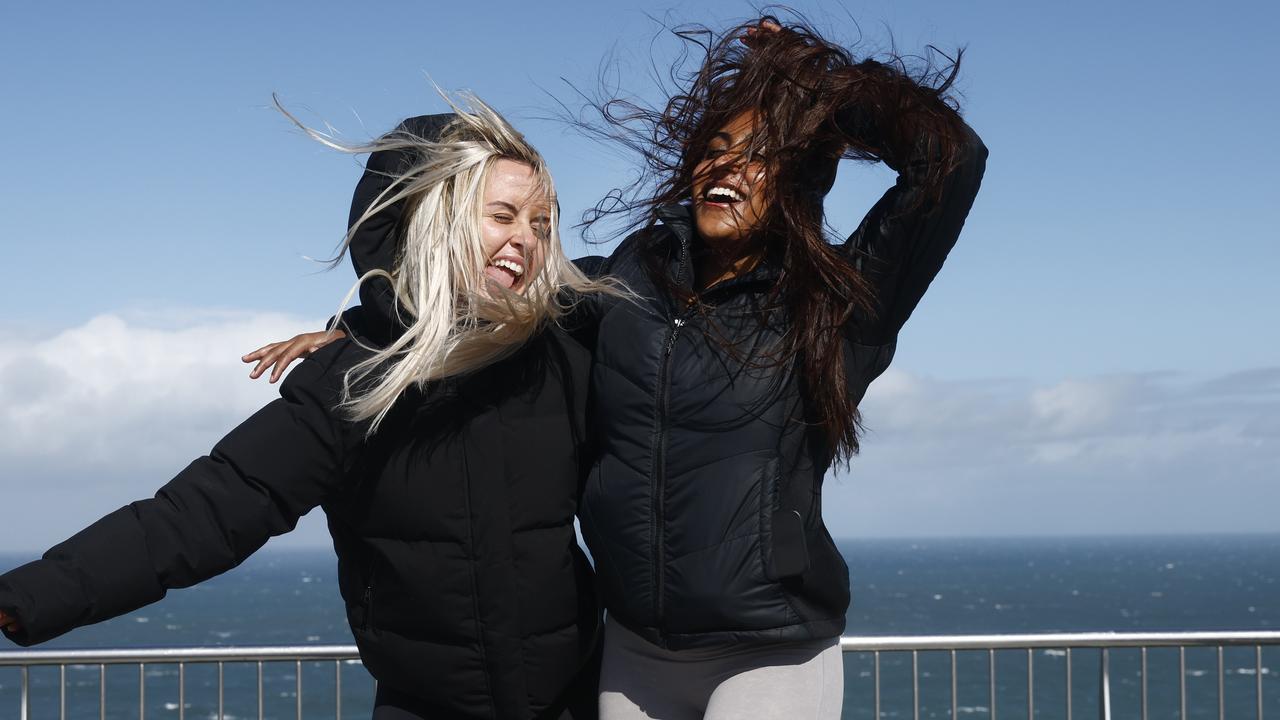 The wind chill factor. Pictured on the Memorial Walk at Merewether Beach near Newcastle is Lily Howdle and Gayathri Rajan getting blasted by the high winds and cold weather being experienced along the NSW coast. Picture: Richard Dobson