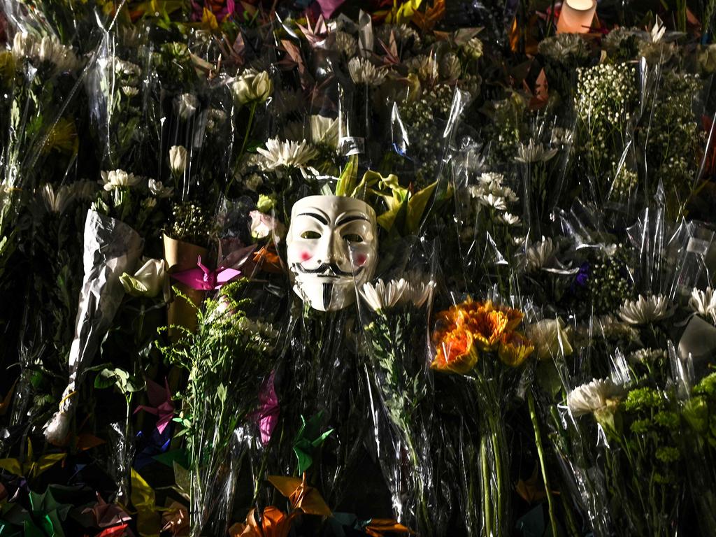 A Guy Fawkes mask is left among flowers during a prayer rally in Tamar Park in Hong Kong. Picture: AFP