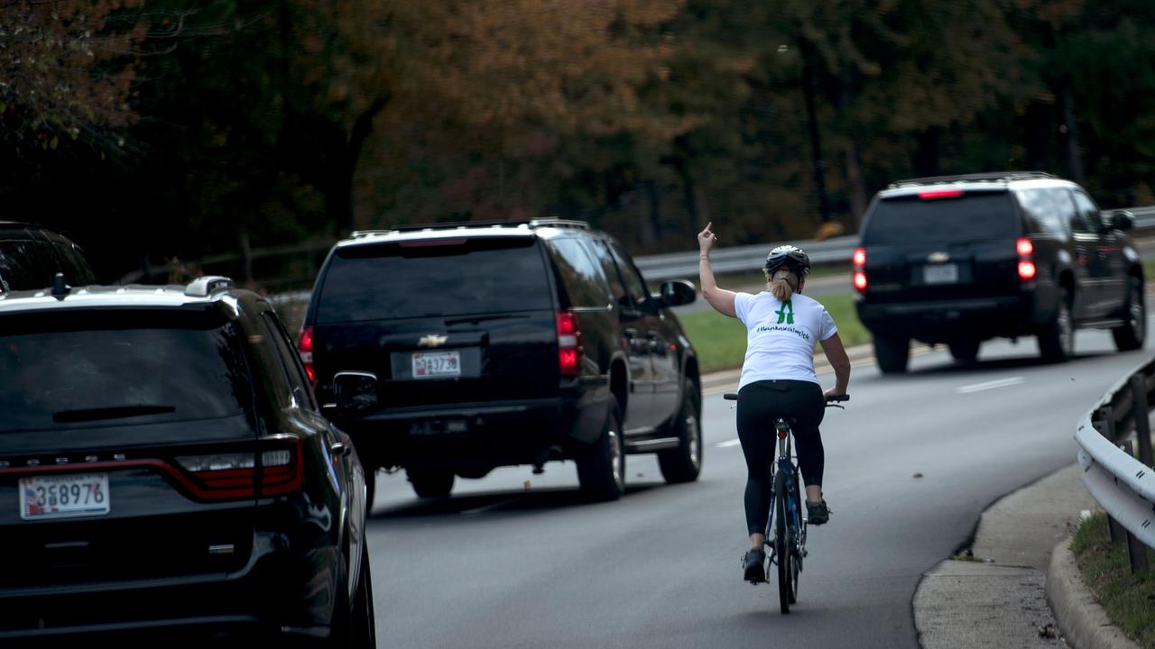 Juli Briskman shows her middle finger as a motorcade with US President Donald Trump departs Trump National Golf Course in Sterling, Virginia. Picture: Brendan Smialowski / AFP.