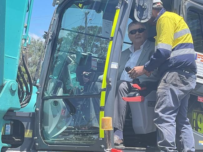 Arthur Laundy jumps in the excavator to turn the sod on the new Lone Pine Plaza in Umina Beach.