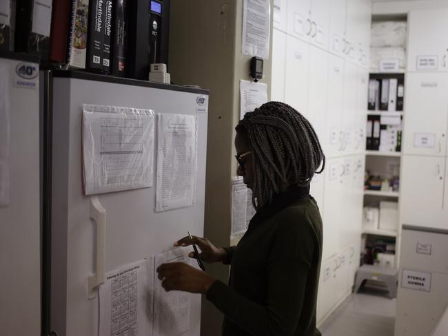 FILE - In a Nov. 30, 2016 file photo, pharmacist Mary Chindanyika looks at documents on a fridge containing a trial vaccine against HIV on the outskirts of Cape Town, South Africa. The latest attempt at an HIV vaccine has failed. Researchers announced Monday, Feb. 3, 2020 they've stopped giving the experimental shots in a major study in South Africa, which has one of the world's highest HIV rates. (AP Photo/Schalk van Zuydam, File)