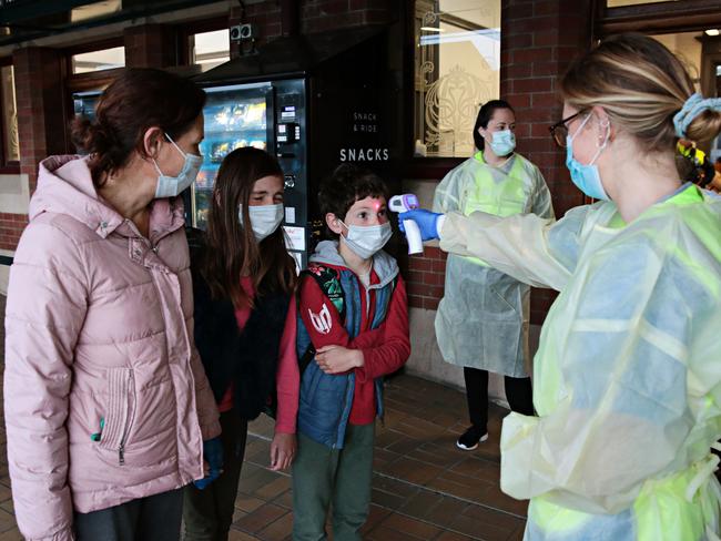 Travellers have their temperature taken after arriving at Sydney’s Central Station on Saturday. Picture: Adam Yip