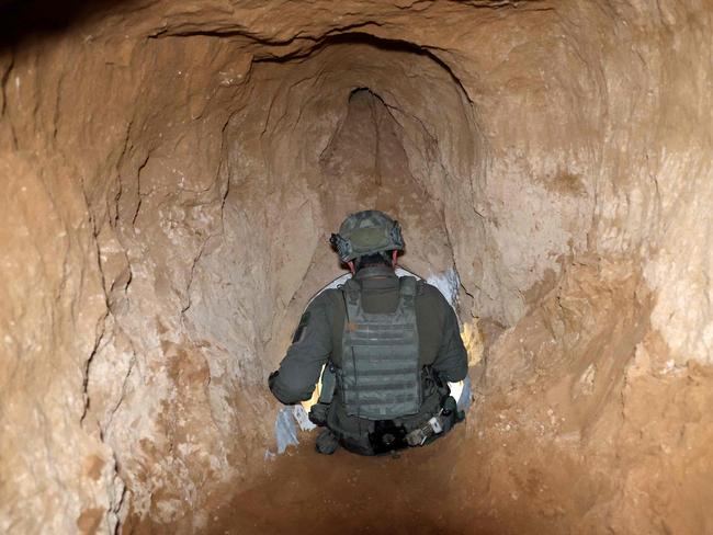 --PHOTO TAKEN DURING A CONTROLLED TOUR AND SUBSEQUENTLY EDITED UNDER THE SUPERVISION OF THE ISRAELI MILITARY-- This picture taken during a media tour organised by the Israeli military on February 8, 2024, shows an Israeli soldier exiting from the entrance of a tunnel that the army claimed is a "Hamas command tunnel" under a compound of the United Nations Relief and Works Agency for Palestine Refugees (UNRWA) in Gaza City, amid the continuing war between Israel and the Palestinian militant group. (Photo by JACK GUEZ / AFP)