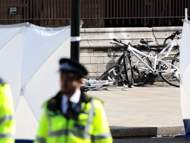 Police officers stand guard near bicycles believed to have been damaged when a vehicle crashed into security barriers near London’s Houses of Parliament. Picture: Getty Images