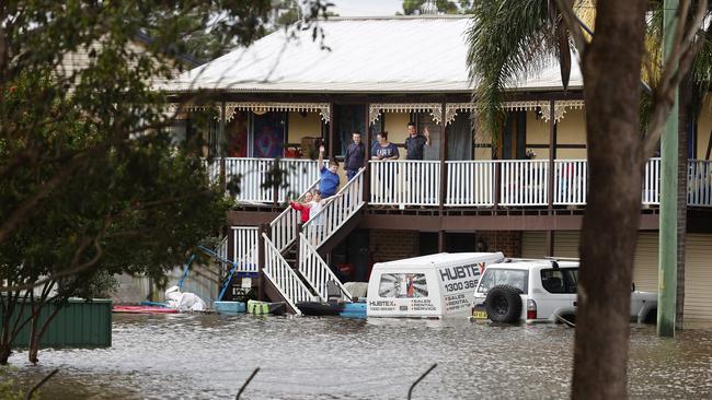 Michael Cook, his partner Ellisha and their kids Ellenna, 6, Lachlan, 9, Colin, 13, and Shannon, 12 are completely surrounded by flood water and can’t leave the house. Picture: Richard Dobson