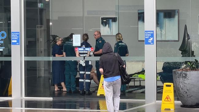 Paramedics treating a woman at the scene for injuries.