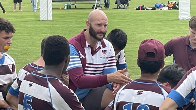 John Paul College coach Joshua Kron addresses his team.