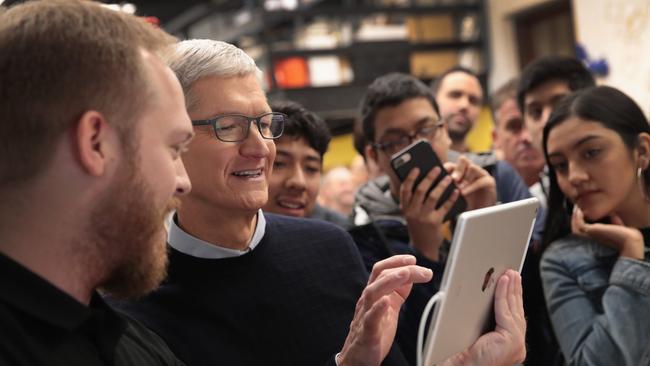 Apple CEO Tim Cook gets a demonstration of an app during the announcement of a new 9.7-inch Apple iPad at Lane Tech College Prep High School in Chicago.