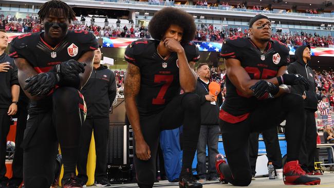 Eli Harold (58), Colin Kaepernick (7), and Eric Reid (35) of the San Francisco 49ers kneel in protest during the national anthem in 2016