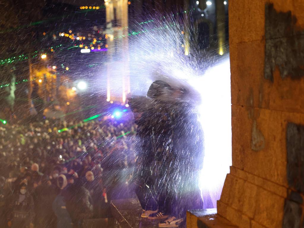 People are hit with water cannons in Tbilisi. Picture: Giorgi ARJEVANIDZE / AFP